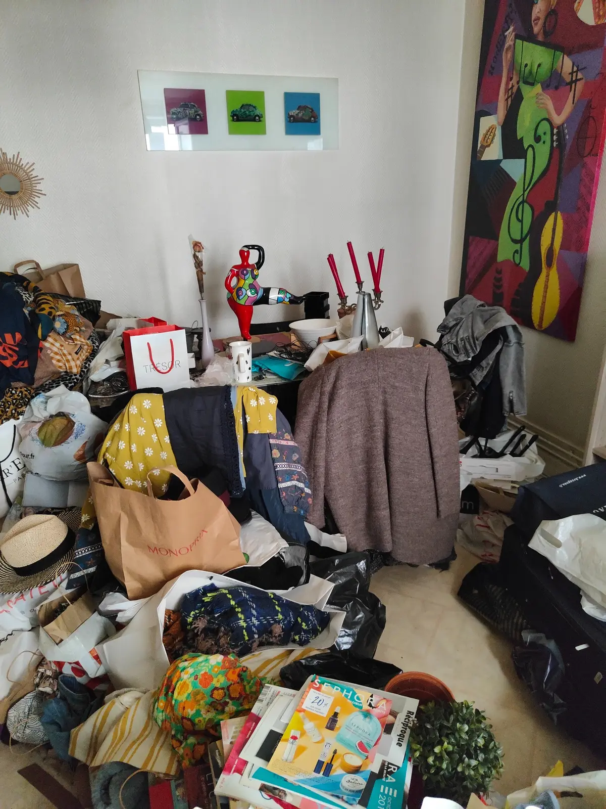 Pièce de vie encombrée de vêtements, meubles et objets personnels
