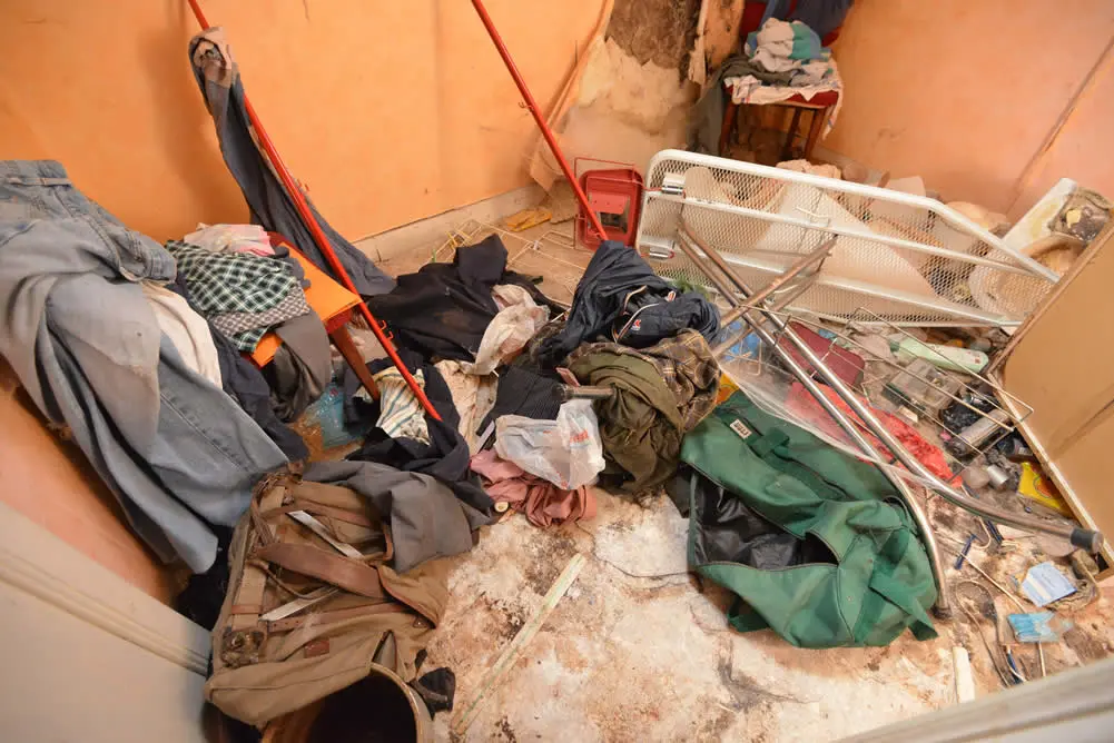 Petite pièce encombrée de vêtements et d’objets divers