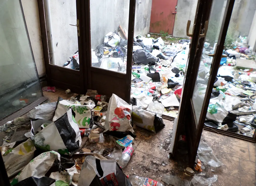 Sol d’un logement couvert de déchets avant évacuation et nettoyage